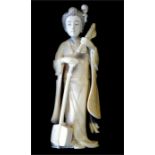 A Japanese stained ivory okimono of a Yamato Nadeshko, standing beside a samisen, 16 cm high,