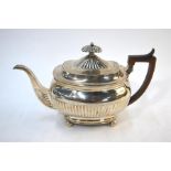 A George III silver half-fluted teapot of oblong form with carved wood handle, on ball feet,