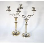 A pair of Continental plated on copper candlesticks, 27 cm, to/w associated scrolling twin-sconce