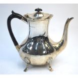 An Edwardian heavy quality oval pear-shaped coffee pot on four pad feet with ebony handle and silver