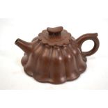 A modern Chinese, Yixing teapot of foliate and ribbed form; the base 12 cm diameter, with a seal