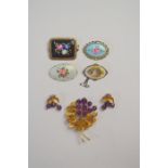 Four enamelled brooches including a Norwegian oval brooch featuring spray of roses and one featuring