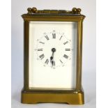 A brass carriage clock with enamel dial, striking on a coiled gong, 17 cm high including handle