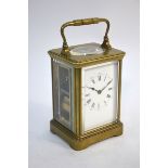 A French brass carriage clock with enamel dial, striking on a coiled gong, 17 cm high overall (inc