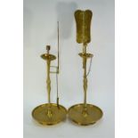 An associated pair of Asian brass candlesticks; each one on a circular base and with a bat decorated