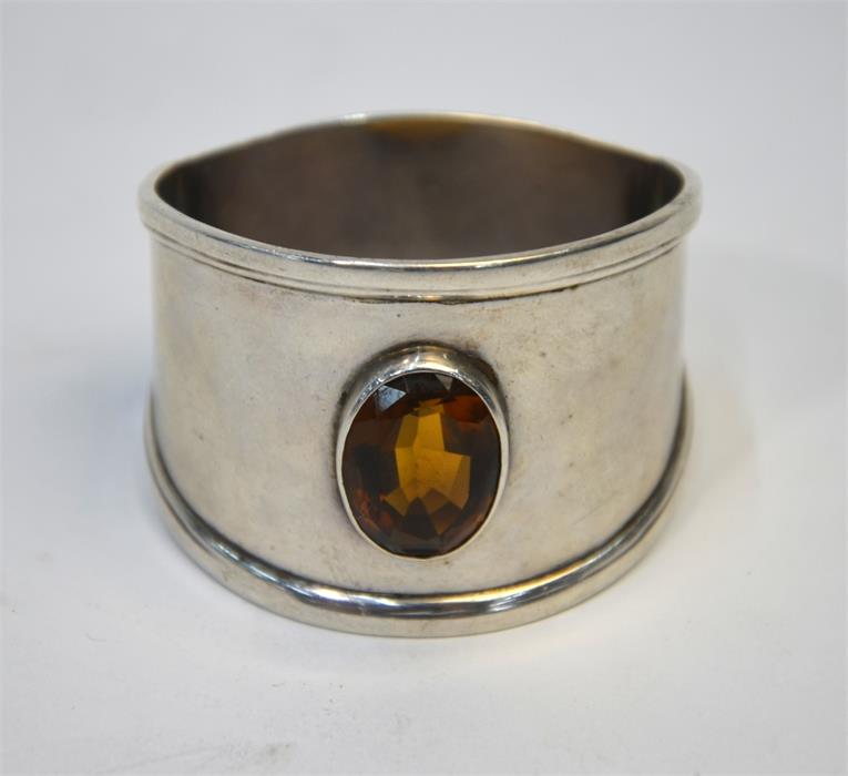 A silver napkin ring set with a dark citrine, B C, Birmingham 1910