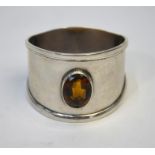 A silver napkin ring set with a dark citrine, B C, Birmingham 1910