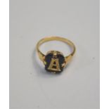 A yellow metal mourning ring with rectangular onyx plaque mounted with initial 'A', stamped 9ct,