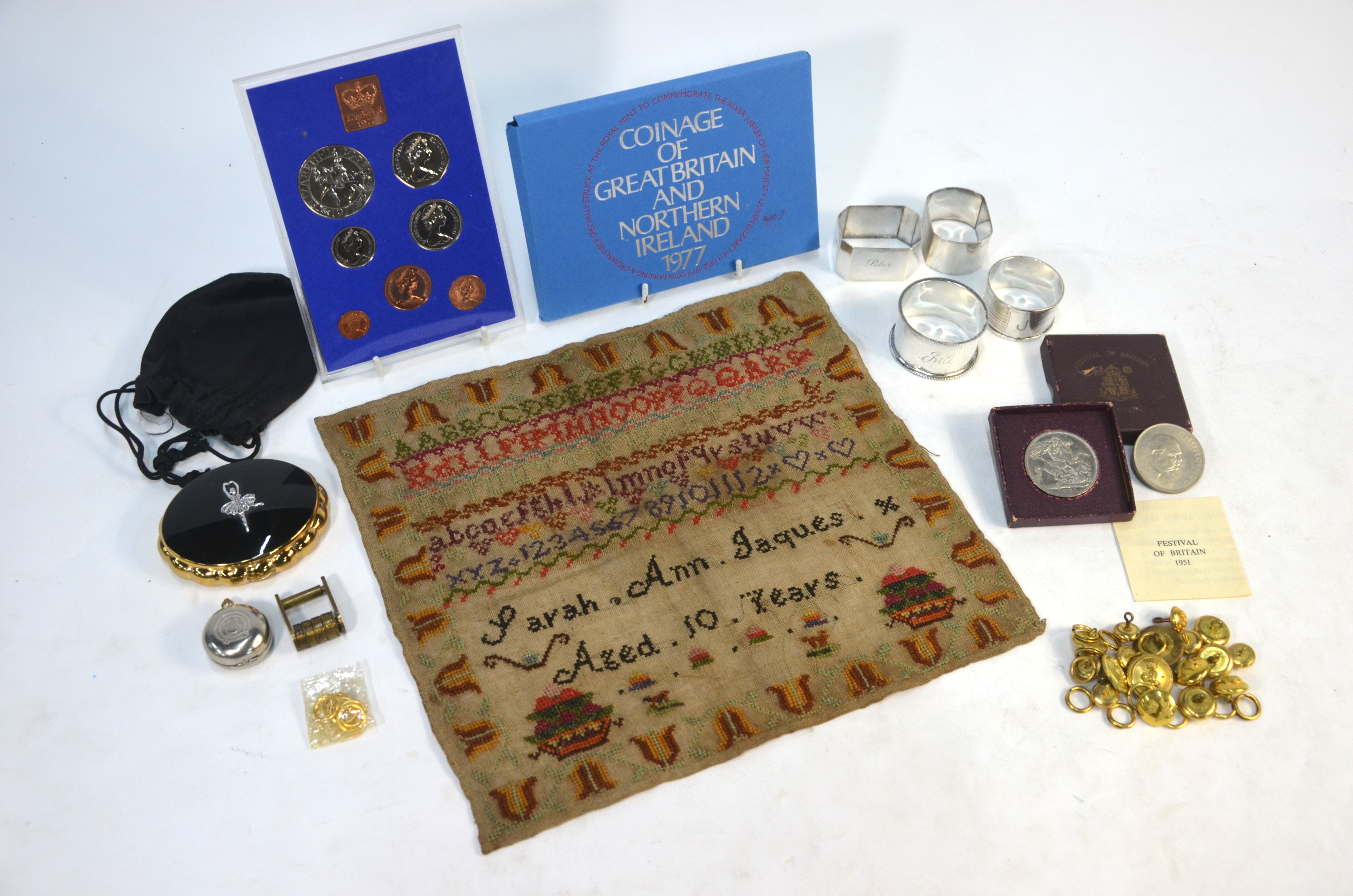 Four silver napkin rings, a Victorian needlework sampler, various military and Air Force brass