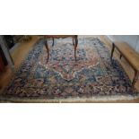 An antique Persian Serapi small carpet, the red/blue ground centred by a geometric floral medallion,