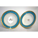 A pair of Minton soup plates, turquoise and gilt border, painted to the centre with an armorial