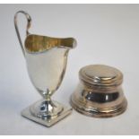 A late Victorian silver cream jug in the Georgian manner with reeded rim and scroll handle, on