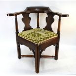 A George III oak and elm corner elbow chair, the flat lobed arms raised on turned columns and fret