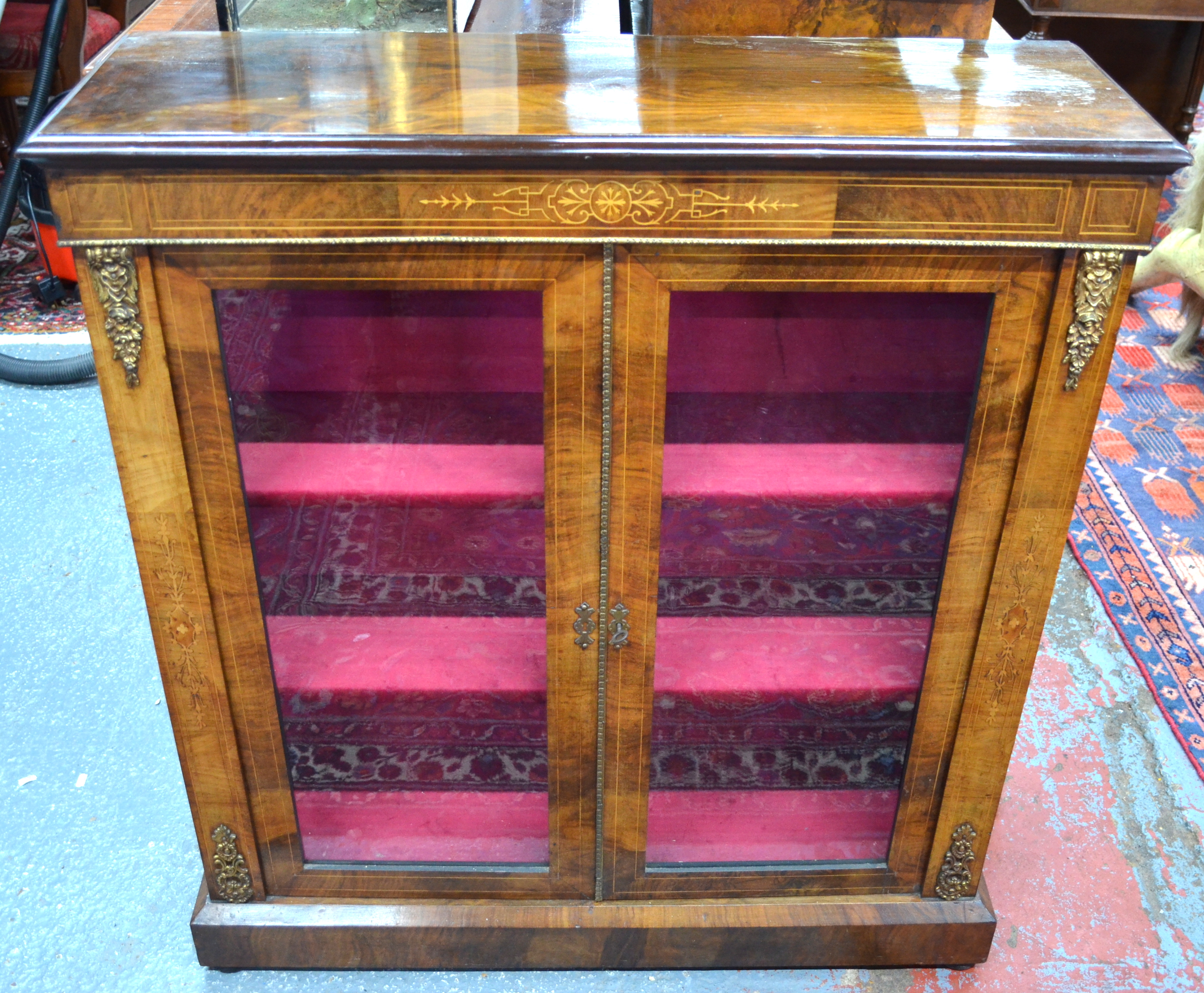 A Victorian satinwood inlaid mahogany cabinet with gilt metal mounts, the two glazed doors opening