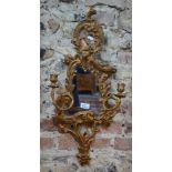 A 19th century giltwood cartel mirror in the Chippendale manner, flanked by twin scroll candle