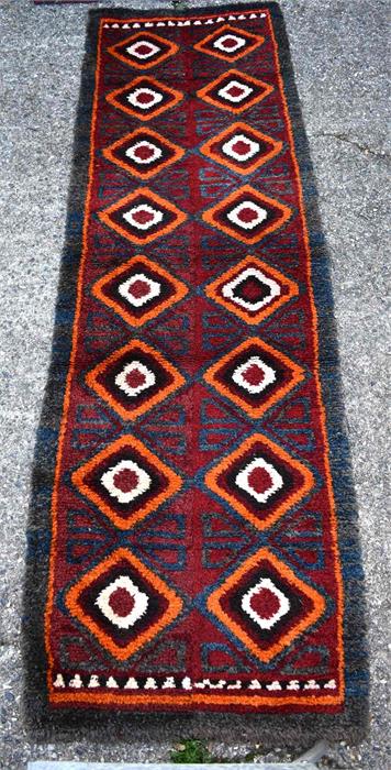 A Julkhyrs rug, circa 1900, the thick wool pile with wine ground and orange diamond design with blue