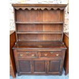 An 18th century oak cottage high dresser, the panelled back rack over two drawers and cupboards