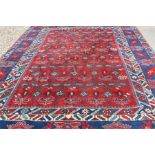 A large Turkish Caucasian design carpet, the overall interlinked stylised floral design on red