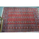 A Turkish design handmade rug, the field of three rows of guls on red ground, 198 cm x 129 cm