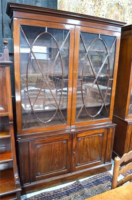 A Victorian mahogany library bookcase with a dentil moulded cornice over a pair of ovoid centred