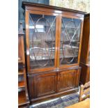 A Victorian mahogany library bookcase with a dentil moulded cornice over a pair of ovoid centred