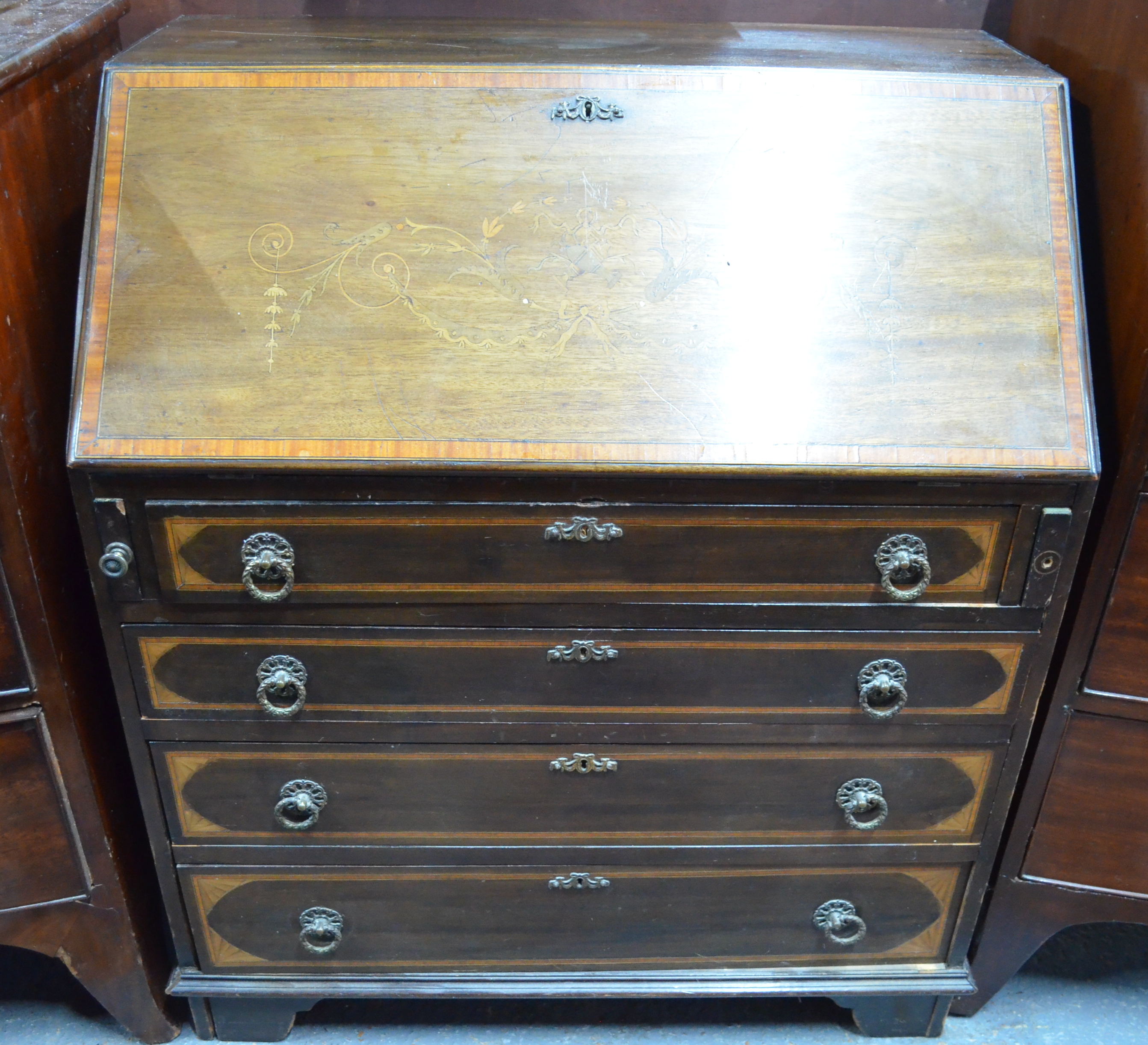 A diminutive Victorian ribbon, bow and batwing inlaid mahogany bureau with fitted interior over four