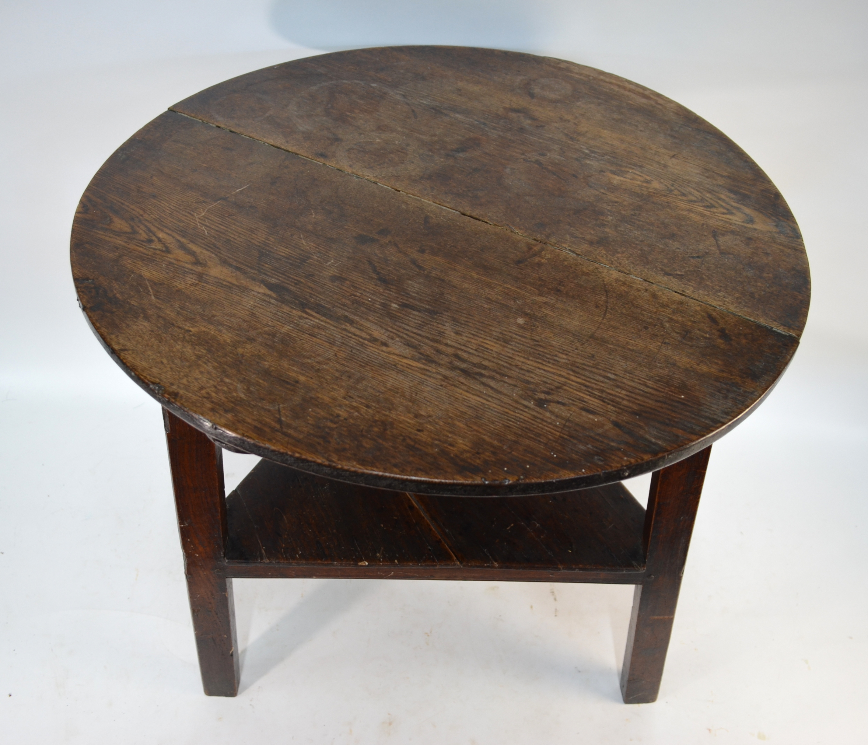An 18th century oak cricket table, the two plank circular top raised on triangular legs united by - Image 2 of 2