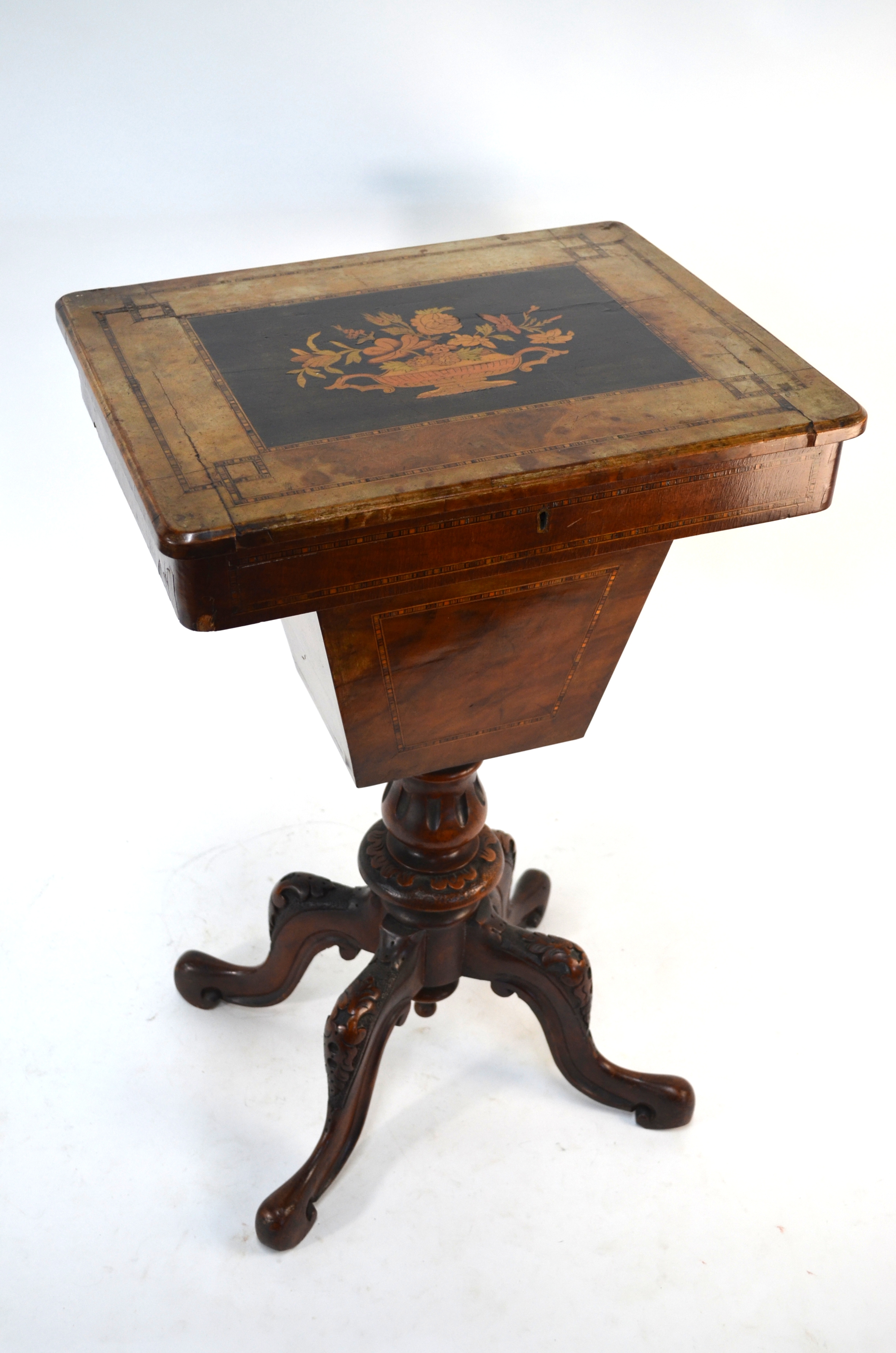 A Victorian walnut work table, the top with inlaid floral urn design hinged to reveal a paper