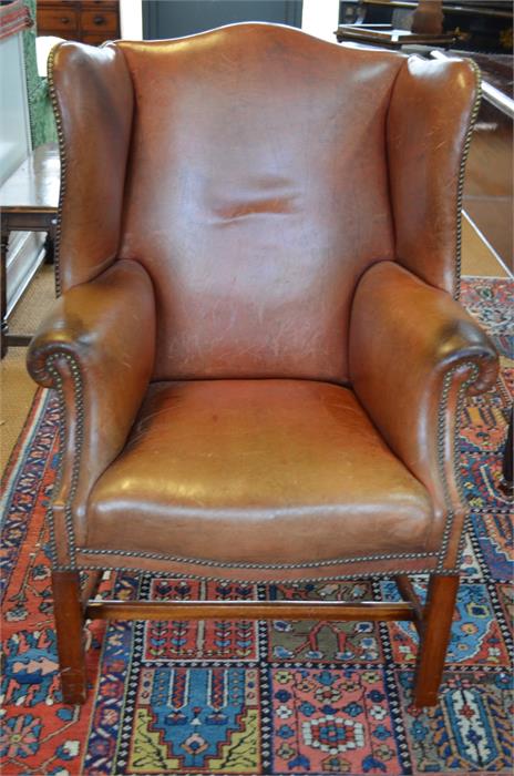 A Georgian style brown studded leather wing armchair