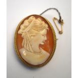 An oval shell cameo brooch featuring profile head of a classical female in 9ct yellow gold rope