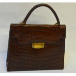 A 1940s brown crocodile handbag with gilt metal clasp lined in fine suede and with lined pouch to