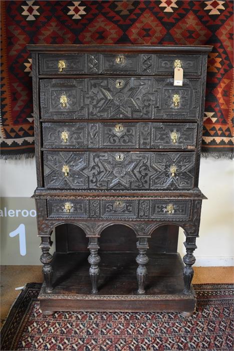 An antique carved oak chest on stand in the 17th century style, having four long irregular drawers