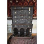 An antique carved oak chest on stand in the 17th century style, having four long irregular drawers