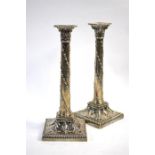 A pair of Edwardian Adam Revival loaded silver candlesticks, the classical columns embossed with