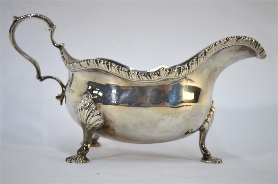 A George V silver sauce boat with scroll handle and shaped gadrooned rim, on three shell feet, - Image 2 of 2