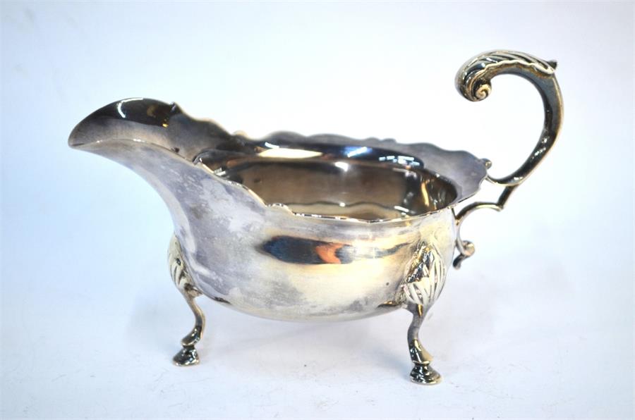 A Victorian sauce boat with scroll handle and shaped rim, on three hoof foot, London 1894, maker