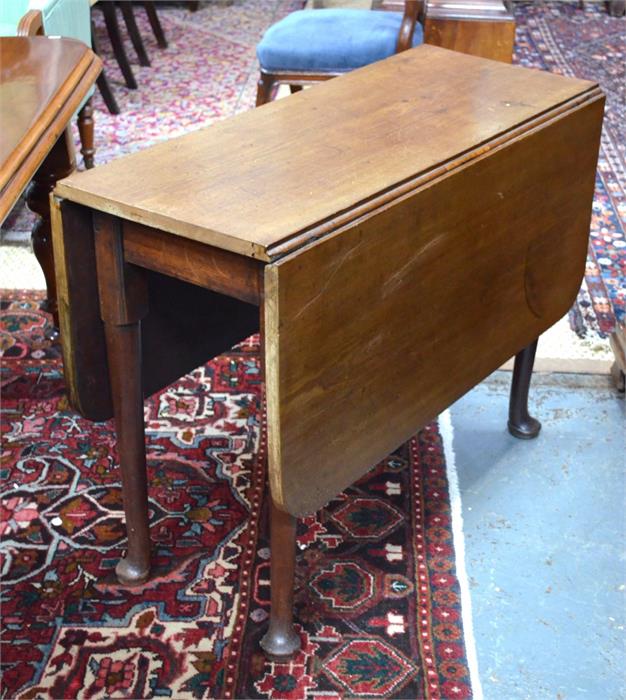 A Georgian mahogany drop leaf supper table raised on turned legs to pad feet