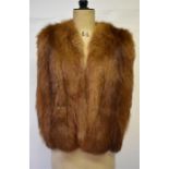 A 1940s russet fox fur evening cape with scalloped edge and side arm slits, with brown crepe