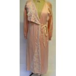 A 1940s peach silk dressing gown lined in ivory silk, with smocked shoulders and cuffs and applicaed