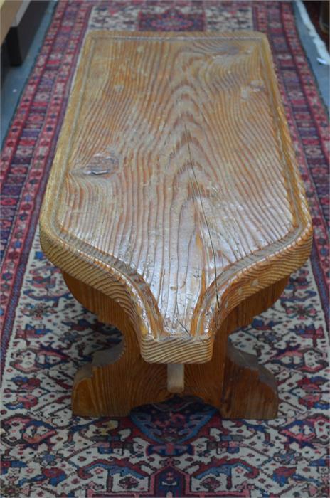 An antique oversized Swiss pine cheese board, later mounted and raised on a trestle base to form a