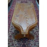 An antique oversized Swiss pine cheese board, later mounted and raised on a trestle base to form a