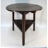 An 18th century oak cricket table, the two plank circular top raised on triangular legs united by
