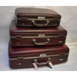 A graduated set of three vintage shadowed brown American Tourister suitcases with combination