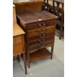 A mahogany music chest with five fall front drawers over an open under-tier