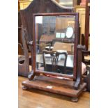 Victorian flame mahogany rectangular toilet mirror on a platform base with turned bun feet