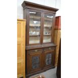 Edwardian oak cabinet bookcase with glazed doors enclosing shelves over two drawers and floral