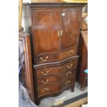 Mahogany serpentine front cabinet on chest with panelled doors over four drawers and central slide