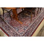 Persian red ground small carpet with central navy floral motif and stylised floral design 244x165cm