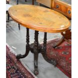 Inlaid walnut oval loo table on quardadorm turned and carved base with castors
