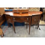 A 19th century mahogany bowfront sideboard with central drawer flanked by cupboards with lion mask